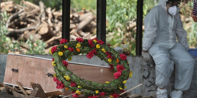 A wreath lies on the coffin of a COVID-19 victim before his cremation in Jammu, India, Friday, April 30, 2021. (Associated Press)