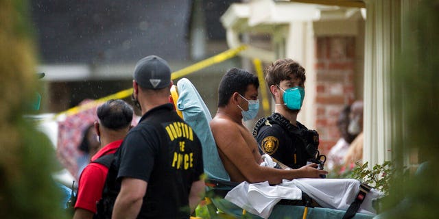 Paramedics transport a man into an ambulance from the scene of a human smuggling case, waar meer as 90 undocumented immigrants were found inside a home on the 12200 block of Chessington Drive, Vrydag, April 30, 2021, in Houston.