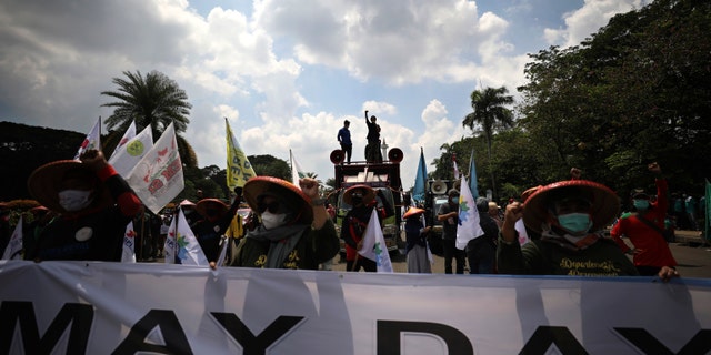 Indonesian workers shout slogan during a May Day rally in Jakarta, Indonesia, Saturday, May 1, 2021. Workers in Indonesia marked international labor day on Saturday curtailed by strict limits on public gatherings to express anger at a new law they say could harm labor rights and welfare. (AP Photo/Dita Alangkara)