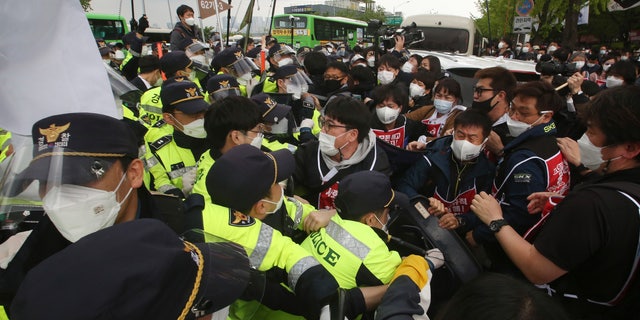 Members of the Korean Confederation of Trade Unions scuffle with police officers during a May Day rally demanding better working conditions and expanding labor rights in Seoul, South Korea, Saturday, May 1, 2021. (AP Photo/Ahn Young-joon)