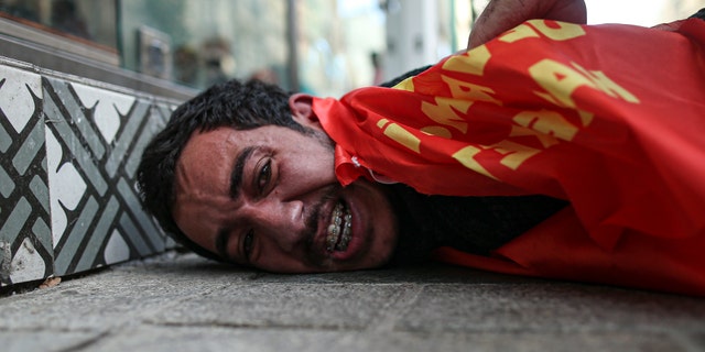 A protester is detained by police after he and others tried to push through a police barricade towards Taksim Square in central Istanbul during May Day protests, Saturday, May 1, 2021. Police in Istanbul detained several demonstrators who tried to march toward Istanbul's symbolic Taksim Square in defiance of the protests ban and the strict lockdown imposed by the government due to the coronavirus outbreak. (AP Photo/Emrah Gurel)