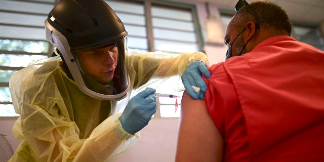 FILE - In this March 10, 2021 file photo, a healthcare worker injects a man with a dose of the Moderna COVID-19 vaccine during a mass vaccination campaign, at the Maria Simmons elementary school in Vieques, Puerto Rico. (AP Photo/Carlos Giusti, File)