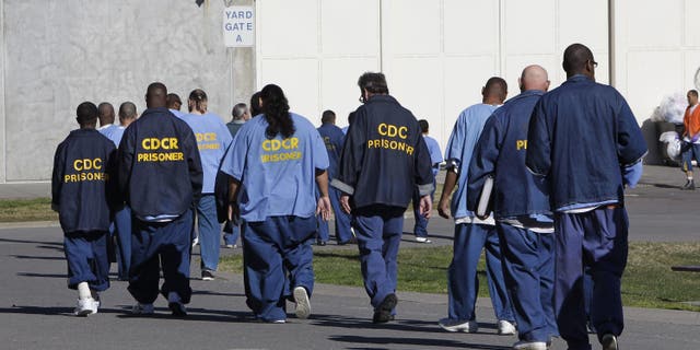 FILE - In this Feb. 26, 2013, file photo, inmates walk through the exercise yard at California State Prison Sacramento, near Folsom, Calif.  (AP Photo/Rich Pedroncelli, File)