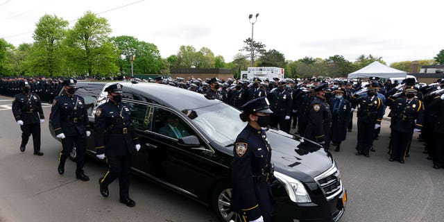 Thousands of police officers line the street as the hearse bearing New York police officer Anastasios Tsakos leaves the St. Paraskevi Greek Orthodox Shrine Church, Tuesday, May 4, 2021, in Greenlawn, N.Y. 