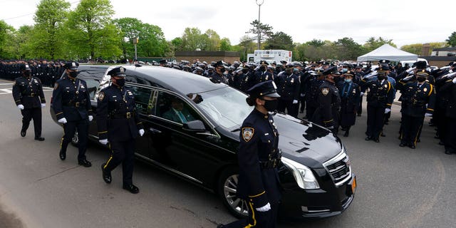 Thousands of police officers line the street as the hearse bearing New York police officer Anastasios Tsakos leaves the St. Paraskevi Greek Orthodox Shrine Church, Tuesday, May 4, 2021, in Greenlawn, N.Y.