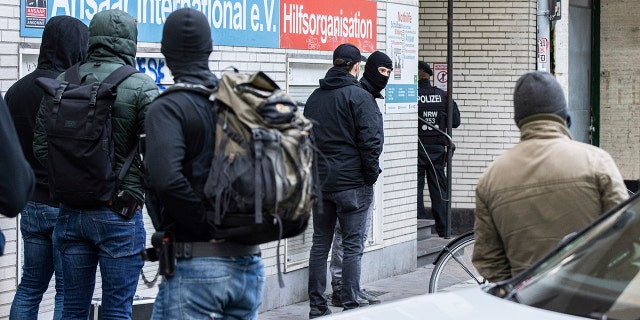 Police officers stay in front of a building of the Ansaar International association in Duesseldorf, Germany, Wednesday, May 5. 2021. (Marcel Kusch/dpa via AP)