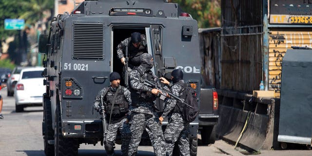 Police get out of an armored vehicle during an operation against alleged drug traffickers in the Jacarezinho favela of Rio de Janeiro, Brazil, Thursday, May 6, 2021.