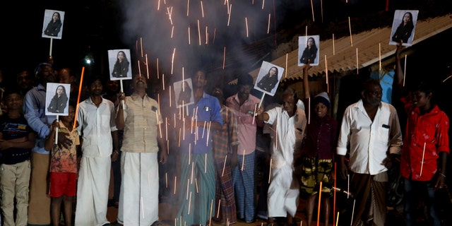 FILE - In this Jan. 20, 2021, file photo, villagers release firecrackers and hold placards featuring Vice President Kamala Harris after her inauguration, in Thulasendrapuram, the hometown of Harris' maternal grandfather, south of Chennai, Tamil Nadu state, India. (AP Photo/Aijaz Rahi, File)