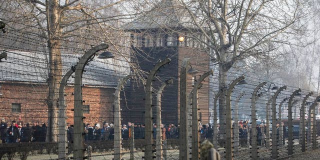 In this file photo taken Jan. 27, 2020, people are seen arriving at the site of the Auschwitz-Birkenau Nazi German death camp, where more than 1.1 million were murdered, in Oswiecim, Poland, for observances marking 75 years since the camp's liberation.