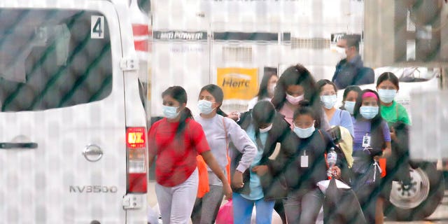 In this April 17, 2021 file photo, teenage migrant girls are loaded into vans to be transported out of the National Association of Christian Churches facility in Houston. The Biden administration is holding tens of thousands of asylum-seeking children in an opaque network of some 200 facilities that The Associated Press has now learned spans two dozen states and includes five shelters with more than 1,000 children packed inside.