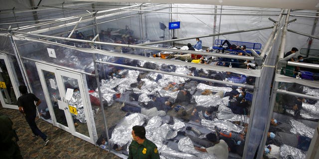In this March 30, 2021 file photo, minors lie inside a pod at the Donna Department of Homeland Security holding facility, the main detention center for unaccompanied children in the Rio Grande Valley run by U.S. Customs and Border Protection (CBP), in Donna, Texas. (AP Photo/Dario Lopez-Mills,Pool, File)