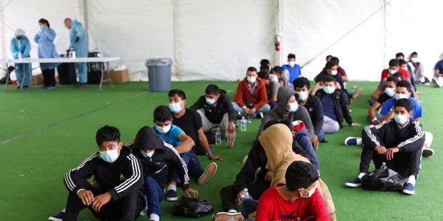 In this March 30, 2021 file photo, young migrants wait to be tested for COVID-19 at the Donna Department of Homeland Security holding facility, the main detention center for unaccompanied children in the Rio Grande Valley, in Donna, Texas. (AP Photo/Dario Lopez-Mills, Pool, File)