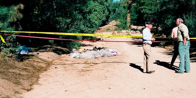 This undated photo provided by the Yavapai County Sheriff's Office shows authorities at the site outside Prescott, Ariz., where Pamela Pitts' body was found in 1988 among a pile of trash. Pitts' then-roommate, Shelly Harmon, recently confessed to killing her and was sentenced to time she already had served in another killing. (Yavapai County Sheriff's Office via AP)
