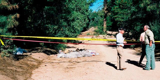 This undated photo provided by the Yavapai County Sheriff's Office shows authorities at the site outside Prescott, Ariz., where Pamela Pitts' body was found in 1988 among a pile of trash. Pitts' then-roommate, Shelly Harmon, recently confessed to killing her and was sentenced to time she already had served in another killing. (Yavapai County Sheriff's Office via AP)