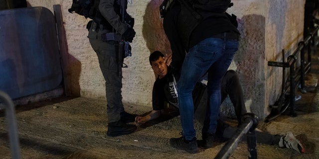 Israeli police detain a Palestinian youth at the Damascus Gate to the Old City of Jerusalem after clashes at the Al-Aqsa Mosque compound, Friday, May 7, 2021. Palestinian worshippers clashed with Israeli police late Friday at the holy site sacred to Muslims and Jews, in an escalation of weeks of violence in Jerusalem that has reverberated across the region. (AP Photo/Maya Alleruzzo)