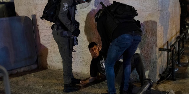Israeli police detain a Palestinian youth at the Damascus Gate to the Old City of Jerusalem after clashes at the Al-Aqsa Mosque compound, Friday, May 7, 2021. Palestinian worshippers clashed with Israeli police late Friday at the holy site sacred to Muslims and Jews, in an escalation of weeks of violence in Jerusalem that has reverberated across the region. (AP Photo/Maya Alleruzzo)