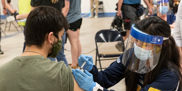 In this April 8, 2021, file photo, Kent State University student Jarrett Woo gets his Johnson &amp; Johnson COVID-19 vaccination from Kent State nursing student Allie Rodriguez in Kent, Ohio.  (AP Photo/Phil Long, File)