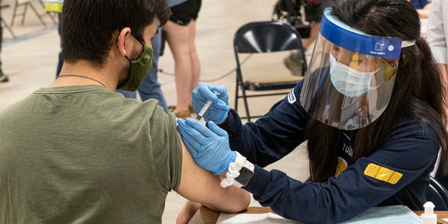 In this April 8, 2021, file photo, Kent State University student Jarrett Woo gets his Johnson & Johnson COVID-19 vaccination from Kent State nursing student Allie Rodriguez in Kent, Ohio. (AP Photo/Phil Long, File)