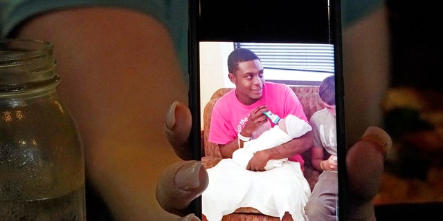 Alexis Rankin holds a 2018 cell phone photograph of her former boyfriend Willie Jones Jr., holding their newborn son, as she recalls the events of February 8, 2018, when Jones was discovered hanging from a tree in the yard of Rankin's family home shortly after arriving there with Rankin. The sheriff's department and the Mississippi Bureau of Investigation, both ruled the death a suicide. However, a Jackson-area judge in April awarded close to $11.4 million to Jones' family in a civil suit claiming wrongful death, alleging that Rankin's stepfather, Harold O'Bryant, Jr., either killed Jones or failed to prevent him from killing himself. (AP Photo/Rogelio V. Solis)