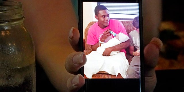 Alexis Rankin holds a 2018 cell phone photograph of her former boyfriend Willie Jones Jr., holding their newborn son, as she recalls the events of February 8, 2018, when Jones was discovered hanging from a tree in the yard of Rankin's family home shortly after arriving there with Rankin. The sheriff's department and the Mississippi Bureau of Investigation, both ruled the death a suicide. However, a Jackson-area judge in April awarded close to $11.4 million to Jones' family in a civil suit claiming wrongful death, alleging that Rankin's stepfather, Harold O'Bryant, Jr., either killed Jones or failed to prevent him from killing himself. (AP Photo/Rogelio V. Solis)