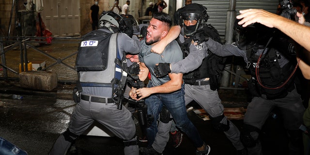 Israeli police officers clash with Palestinian protesters near Damascus Gate just outside Jerusalem's Old City, Sunday, May 9, 2021. (AP Photo/Ariel Schalit)