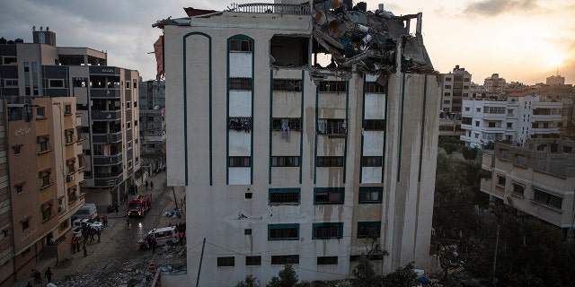 Palestinians search for survivors under the rubble of a destroyed rooftop of a residential building which was hit by Israeli missile strikes, at the Shati refugee camp in Gaza City, early Tuesday, May. 11, 2021. (AP Photo/Khalil Hamra)