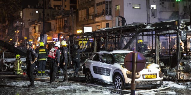 An Israeli firefighter works at the site where a rocket fired from the Gaza Strip, hit the central Israeli town of Holon, near Tel Aviv, Tuesday, May 11, 2021. (AP Photo/Heidi Levine)