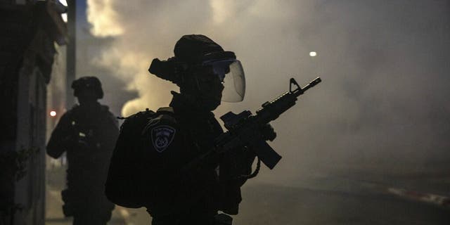 Israeli forces run during clashes with Israeli Arabs in the Israeli mixed city of Lod, Israel, Tuesday, May 11,2021. (AP Photo/Heidi Levine)
