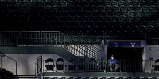 A fan watches from the stands during the second inning of a baseball game between the Milwaukee Brewers and the St. Louis Cardinals on Tuesday, May 11, 2021, in Milwaukee. (AP Photo/Aaron Gash)