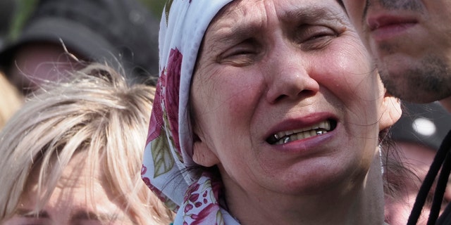 A woman mourns at the funeral of Elvira Ignatieva, an English teacher who was killed in a school shooting Tuesday in Kazan, Russia on Wednesday, May 12, 2021. Russian officials say a gunman attacked a school in the city of Kazan and Russian officials say several people were killed. Officials said the deaths in Tuesday's shooting included students, a teacher and a school employee. Authorities also say more than 20 other people have been hospitalized with injuries. (AP Photo / Dmitri Lovetsky)