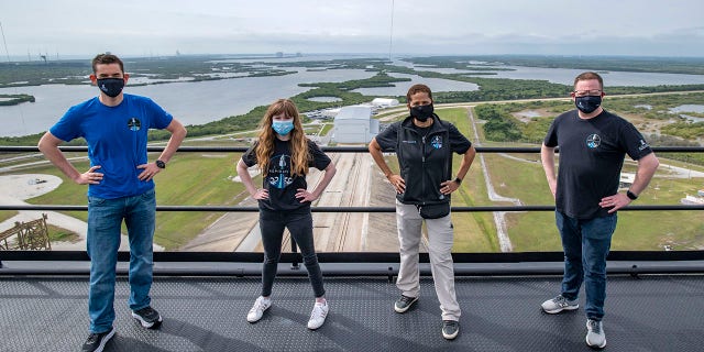 FILE - In this Monday, March 29, 2021 photo provided by SpaceX, from left, Jared Isaacman, Hayley Arceneaux, Sian Proctor and Chris Sembroski pose for a photo on the SpaceX launch tower at NASA's Kennedy Space Center at Cape Canaveral, Fla. SpaceX’s high tech capsules are completely automated, as are Blue Origin’s. So should wealthy riders and their guests be called astronauts even if they learn the ropes in case they need to intervene in an emergency? (SpaceX via AP, File)