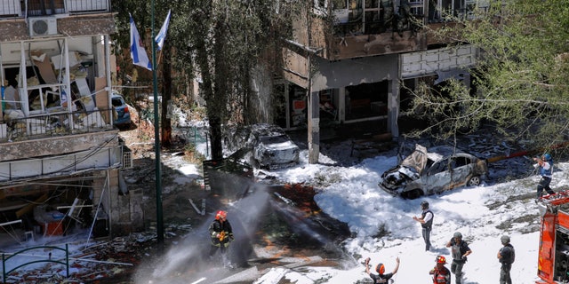 Israeli security forces and emergency services work on a site hit by a rocket fired from the Gaza Strip, in Ramat Gan, central Israel, Saturday, May 15, 2021. (AP Photo/Oded Balilty)