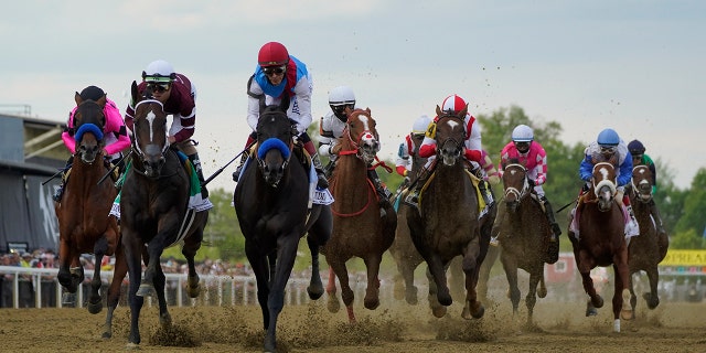 John Velazquez atop Medina Spirit, center left, leads the pack out of the gates during the 146th Preakness Stakes horse race at Pimlico Race Course, sábado, Mayo 15, 2021, in Baltimore.