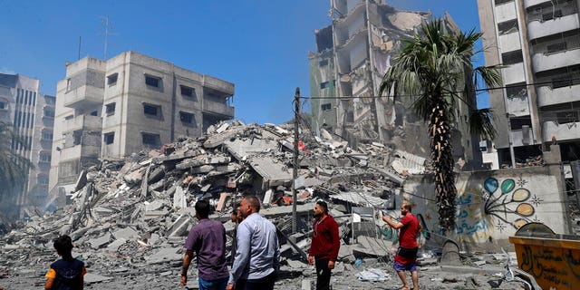 People insect the rubble of the Yazegi residential building that was destroyed by an Israeli airstrike, in Gaza City, Sunday, May 16, 2021.