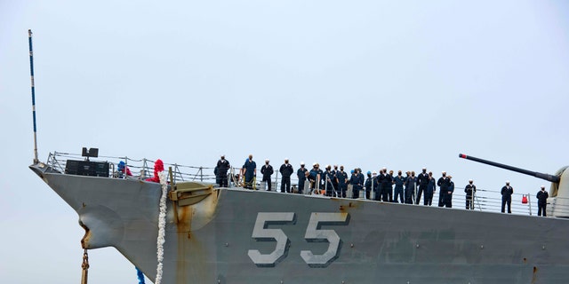 In this photo provided by the U.S. Navy, sailors aboard the guided missile destroyer USS Stout handle mooring lines during the ship's return to home port at Naval Station Norfolk, in Norfolk, Va., in this Oct. 12, 2020, photo. The USS Stout showed rust as it returned from the 210-day deployment. The rust was quickly removed, and the ship repainted. But the rusty ship and its weary crew underscored the costly toll of deferred maintenance on ships and long deployments on sailors. (Spc. Jason Pastrick/U.S. Navy via AP)