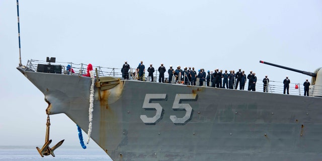 In this photo provided by the U.S. Navy, sailors aboard the guided missile destroyer USS Stout handle mooring lines during the ship's return to home port at Naval Station Norfolk, in Norfolk, Va., in this Oct. 12, 2020, photo. The USS Stout showed rust as it returned from the 210-day deployment. The rust was quickly removed, and the ship repainted. But the rusty ship and its weary crew underscored the costly toll of deferred maintenance on ships and long deployments on sailors. (Spc. Jason Pastrick/U.S. Navy via AP)