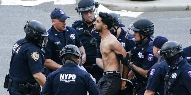 A man is detained by police as Palestinian supporters gather during a demonstration near the United Nations headquarters Tuesday, May 18, 2021, in New York. (AP Photo/Frank Franklin II)