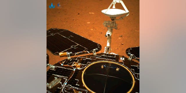 The rover's solar panels and antenna are deployed as the rover sits on its lander on the surface of Mars. 