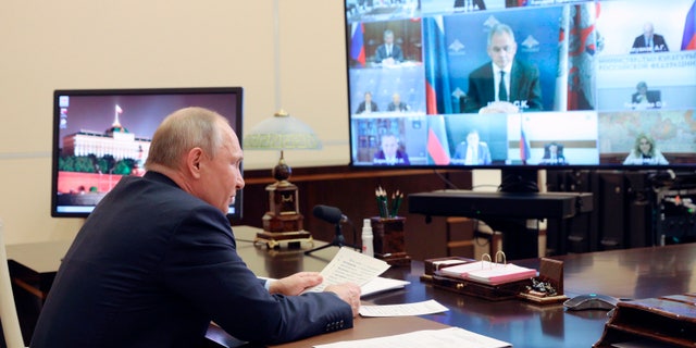 Russian President Vladimir Putin chairs a meeting of Pobeda (Victory) organising committee via teleconference at the Novo-Ogaryovo residence outside Moscow, Russia, Thursday, May 20, 2021. Russian President Vladimir Putin alleged Thursday that some of the country's foreign foes dream about biting off pieces of the country's vast territory, warning that Moscow would "knock their teeth out" if they ever try. (Sergei Ilyin, Sputnik, Kremlin Pool Photo via AP)