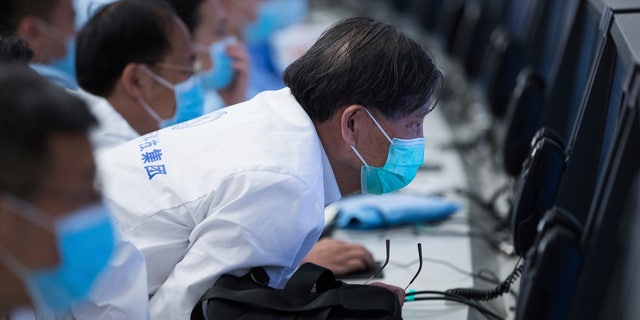 In this photo released by China's Xinhua News Agency, technicians monitor the progress of China's Zhurong Mars rover at the Beijing Aerospace Control Center in Beijing, Saturday, May 22, 2021. China's first Mars rover has driven down from its landing platform and is now roaming the surface of the red planet, China's space administration said Saturday. (Jin Liwang/Xinhua via AP)