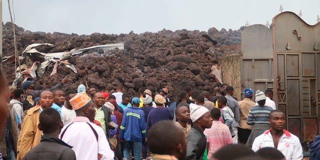 Residents check the damages caused by lava from the overnight eruption of Mount Nyiragongo in Buhene, on the outskirts of Goma, Congo in the early hours of Sunday, May 23, 2021. Congo's Mount Nyiragongo erupted for the first time in nearly two decades Saturday, turning the night sky a fiery red and sending lava onto a major highway as panicked residents tried to flee Goma, a city of nearly 2 million. (AP Photo/Justin Kabumba)