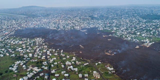 Lava from the eruption of Mount Nyiragongo cuts through Buhene north of Goma, Congo Monday, May 24, 2021. Residents returned to destroyed homes and searched for missing loved ones on the outskirts of Goma as officials called for vigilance amid small tremors after the large volcano erupted Saturday May 22, 2021 .  Mount Nyiragongo sent torrents of lava into villages after dark with little warning, leaving at least 15 people dead amid the chaos and destroying more than 500 homes. (AP Photo/Justin Kabumba)