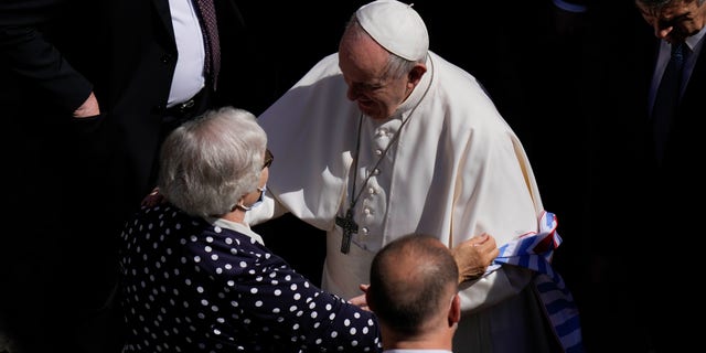 Pope Francis talks with Lidia Maksymowicz, a Holocaust survivor, who was a prisoner in the Auschwitz-Birkenau extermination camp before leaving San Damaso Courtyard at the Vatican for his weekly general audience, Wednesday, May 26, 2021. (AP Photo/Alessandra Tarantino)