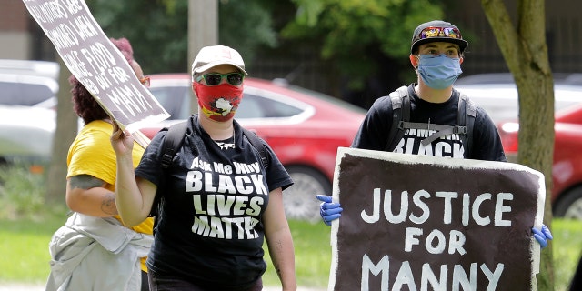 A protester holds a sign that reads "Justice for Manny" in this June 5, 2020 file photo in Tacoma, Wash., during a protest against police brutality. (Associated Press)