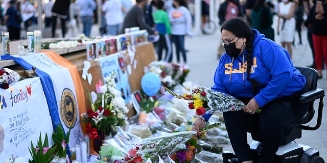 Diana Carreras places flowers at a vigil at City Hall in San Jose, California, Thursday, May 27, 2021, in honor of the multiple people killed when a gunman opened fire at a rail yard the day before. (Associated Press)