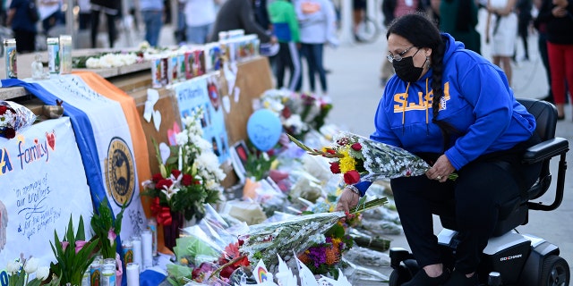 Diana Carreras places flowers at a vigil at City Hall in San Jose, California, Thursday, May 27, 2021, in honor of the multiple people killed when a gunman opened fire at a rail yard the day before. (Associated Press)