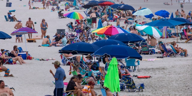 Beachgoers gather in the Cherry Grove section of North Myrtle Beach, S.C., Saturday, May 29, 2021. (Jason Lee/The Sun News via AP)