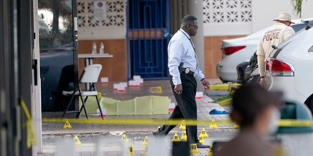 Law enforcement officials work the scene of a shooting outside a banquet hall near Hialeah, Fla., Sunday, May 30, 2021. Two people died and an estimated 20 to 25 people were injured in a shooting outside a banquet hall in South Florida, police said. The gunfire erupted early Sunday at the El Mula Banquet Hall in northwest Miami-Dade County, near Hialeah, police told news outlets. (AP Photo/Lynne Sladky)