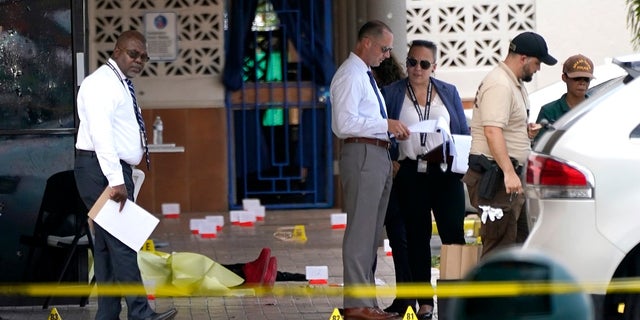 Law enforcement officers work at the scene of a mass shooting outside a banquet hall near Hialeah, Florida, on Sunday. (AP Photo/Lynne Sladky)