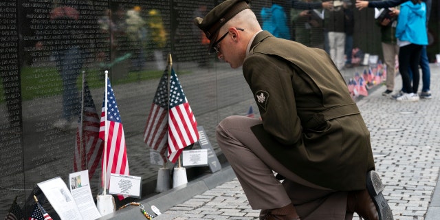 Army Spc. Joseph Wolfe reads the names of the fallen soldiers at Vietnam Veterans Memorial at the National Mall ahead of Memorial Day, in Washington, Sunday, May 30, 2021. (AP Photo/Jose Luis Magana)